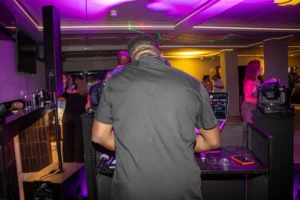 DJ playing music on laptop and decks during private party at GB10 Sports Hub.