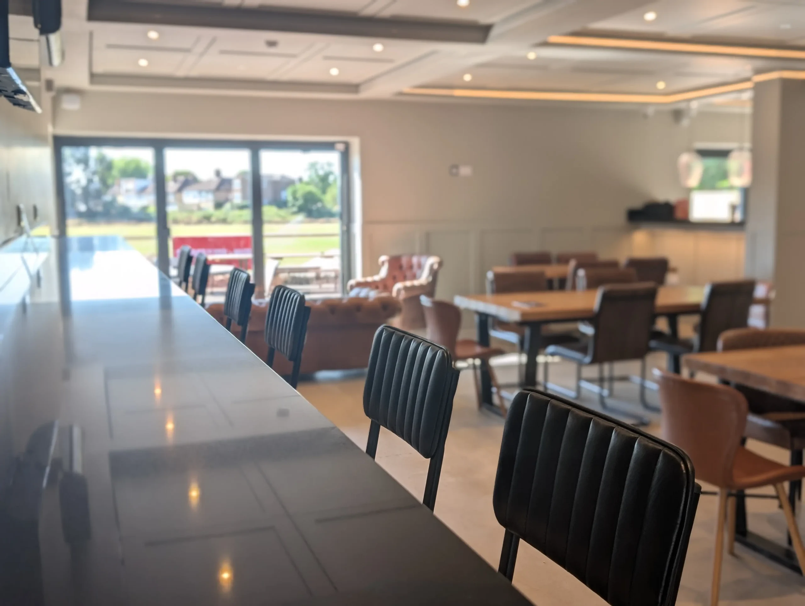 Bar seating area with stools and pendant lights inside GB10 Eltham event space.