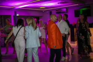Guests dancing indoors with purple lighting at GB10 Sports Hub private party.
