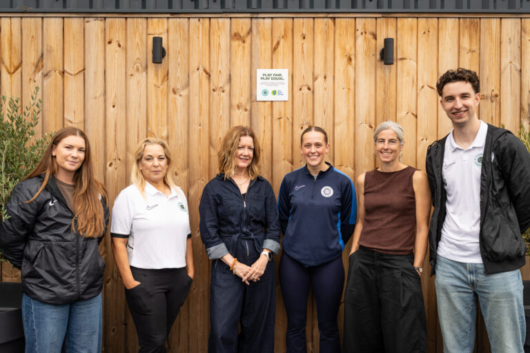 Five women and a man pose outside GB10 Sports alongside the newly installed London FA ‘Play Fair. Play Equal.’ kitemark plaque, celebrating the venue’s recognition for meeting essential standards supporting safe, accessible and inclusive football for women and girls.